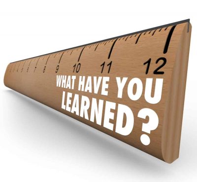 The question What Have You Learned? on a wooden ruler asking you to assess what knowledge you have attained through education